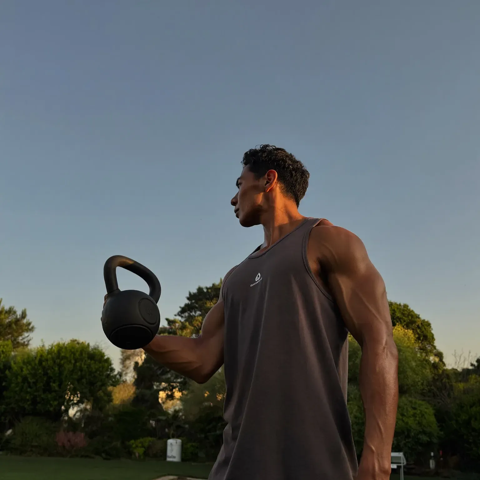 A man lifting a kettlebell outdoors