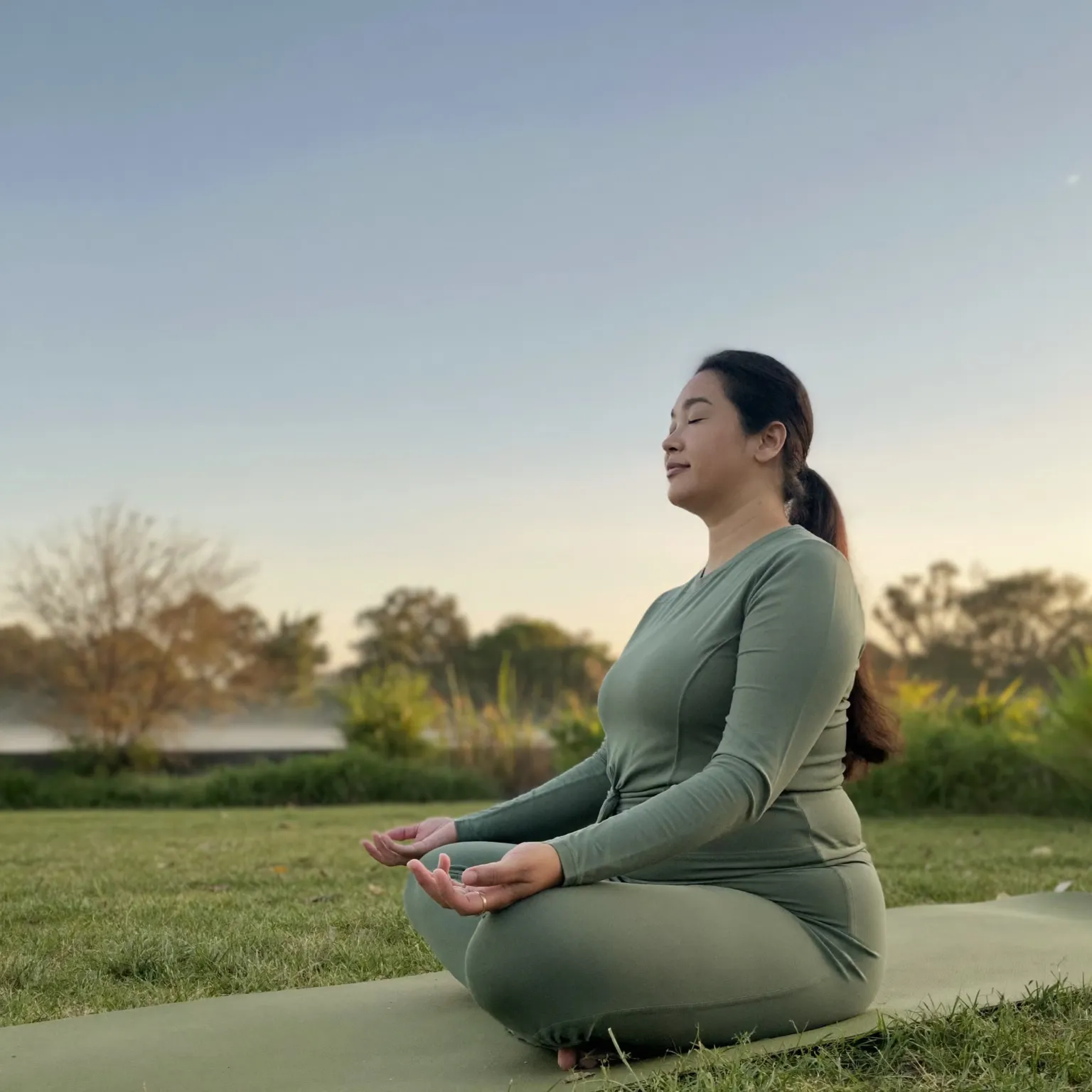 A woman sitting calmly outdoors