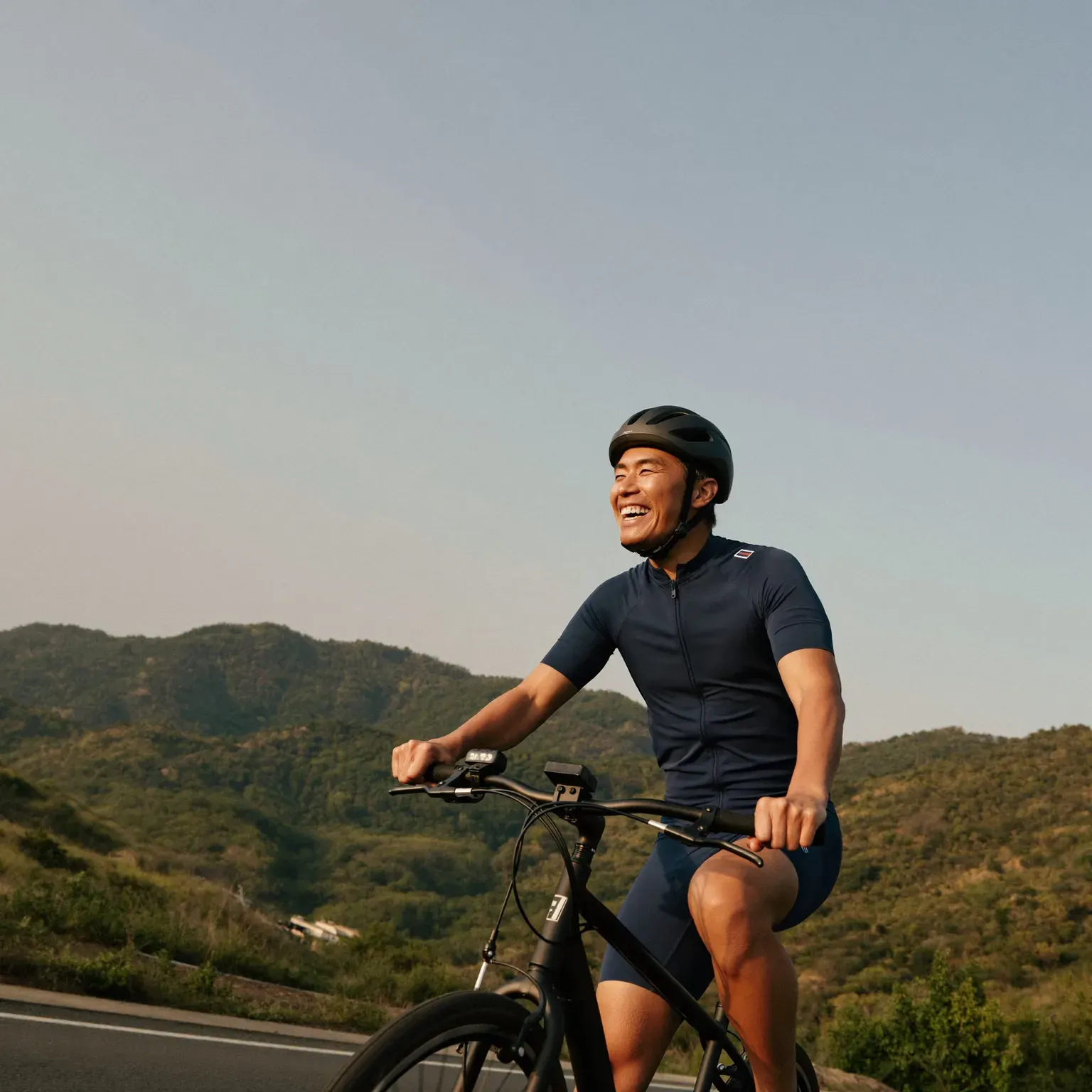 A man cycling on a hillside road