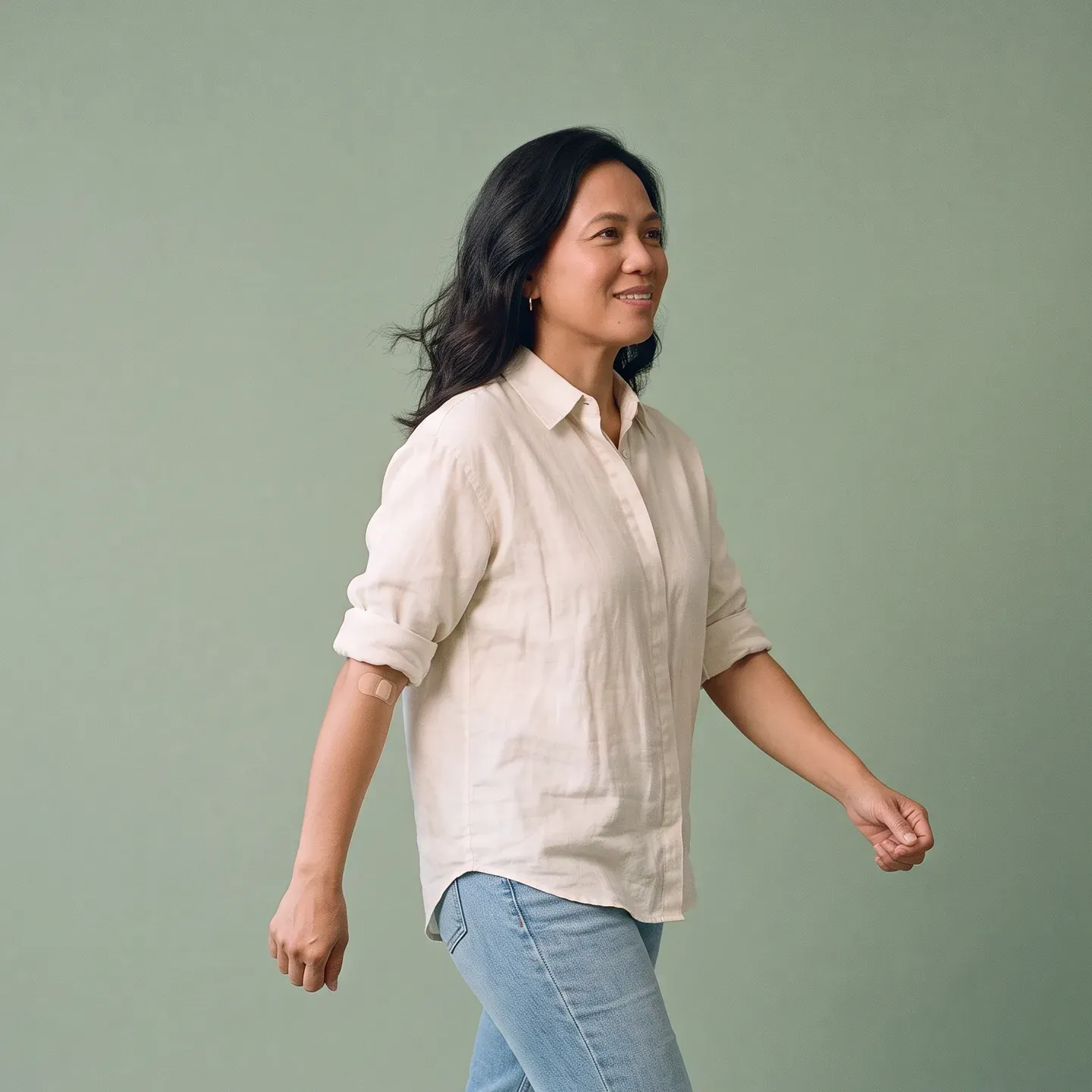 A woman out for a brisk walk, a small plaster on the inside of her elbow