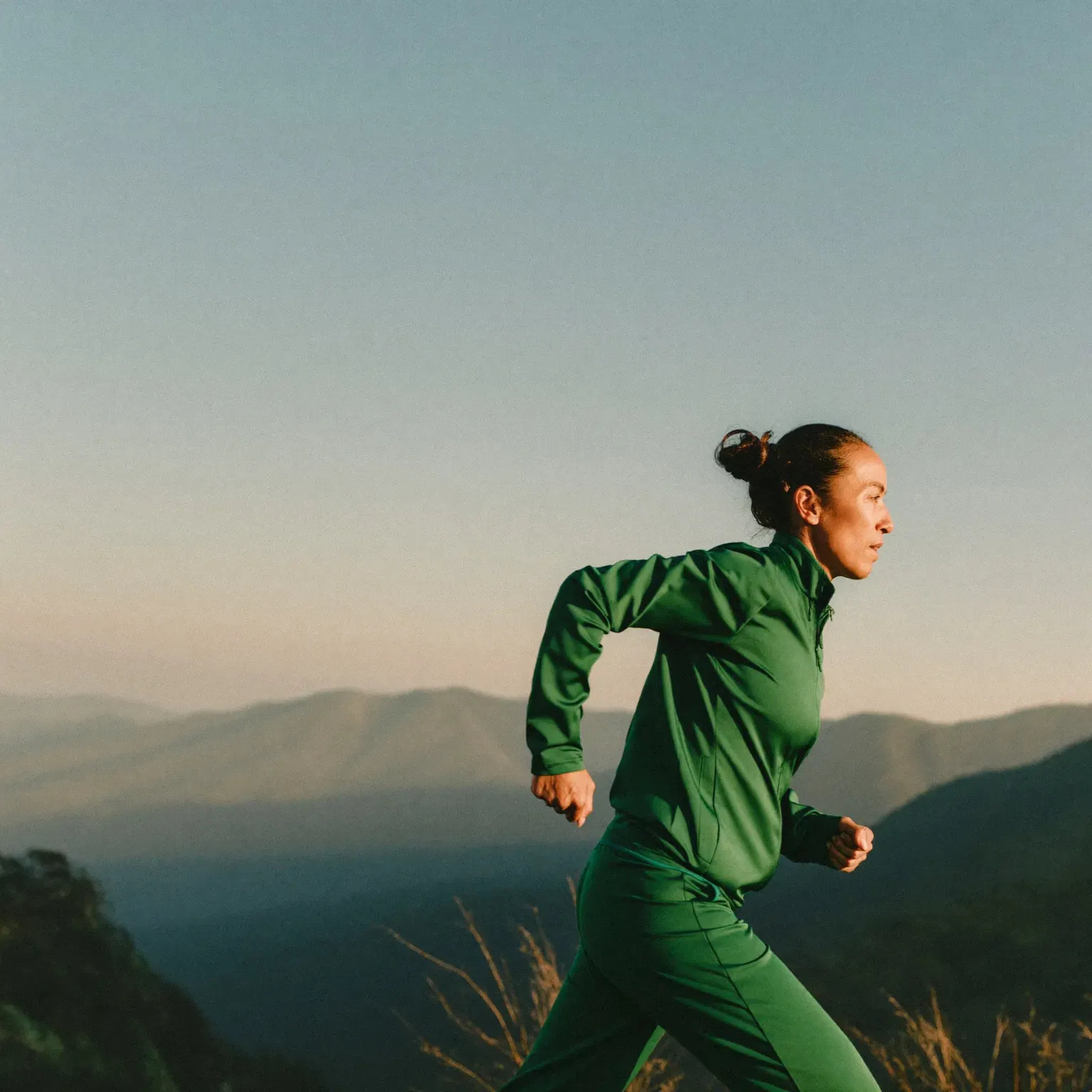 A woman running on a hillside trail