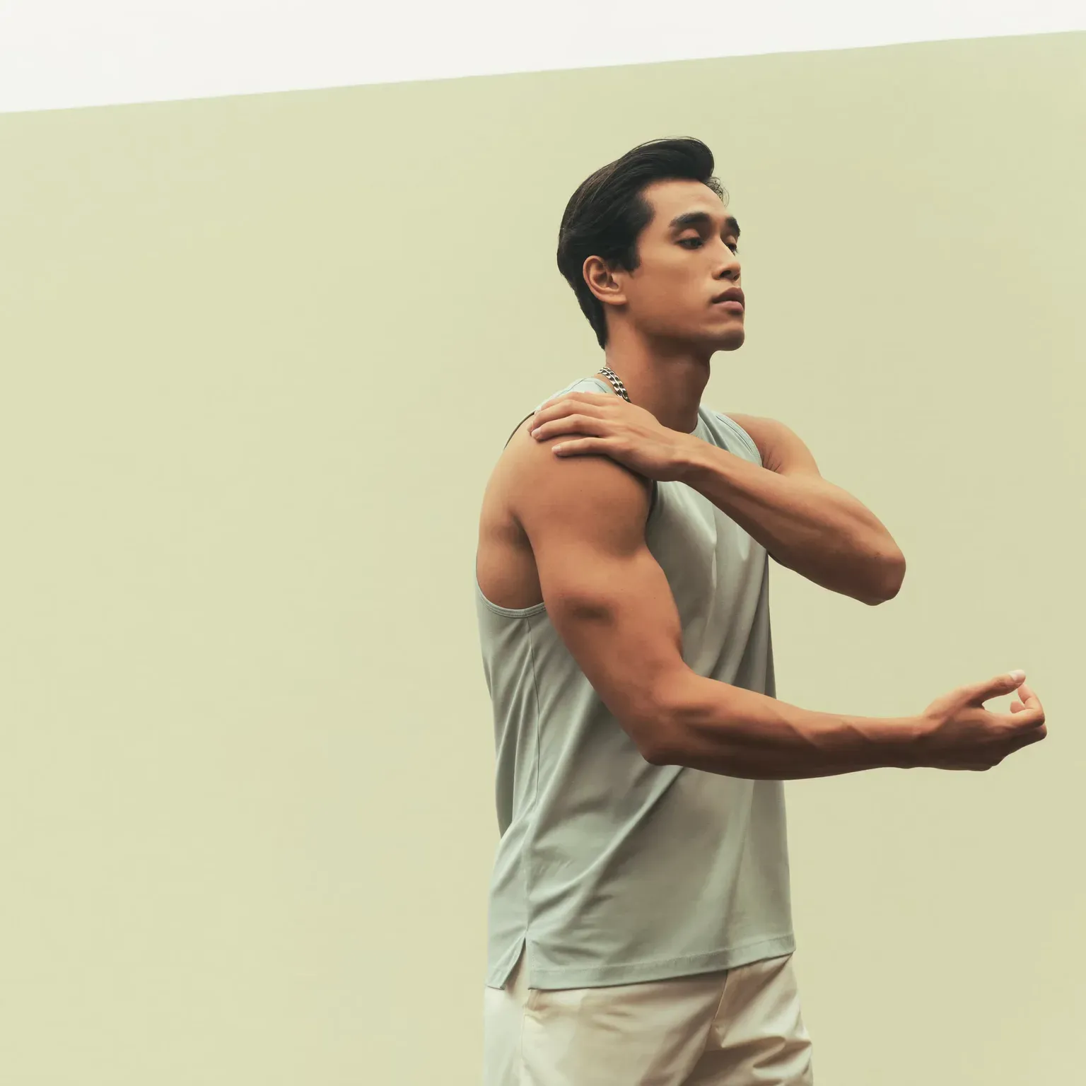 A man holding his shoulder and stretching his arm