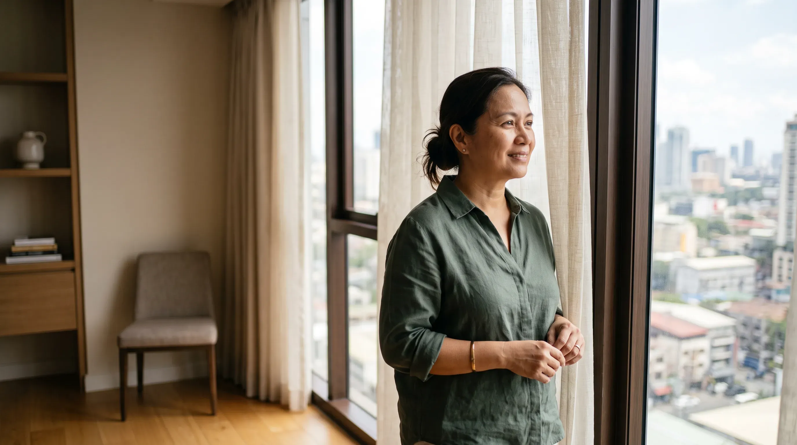 A woman by a tall window in soft daylight