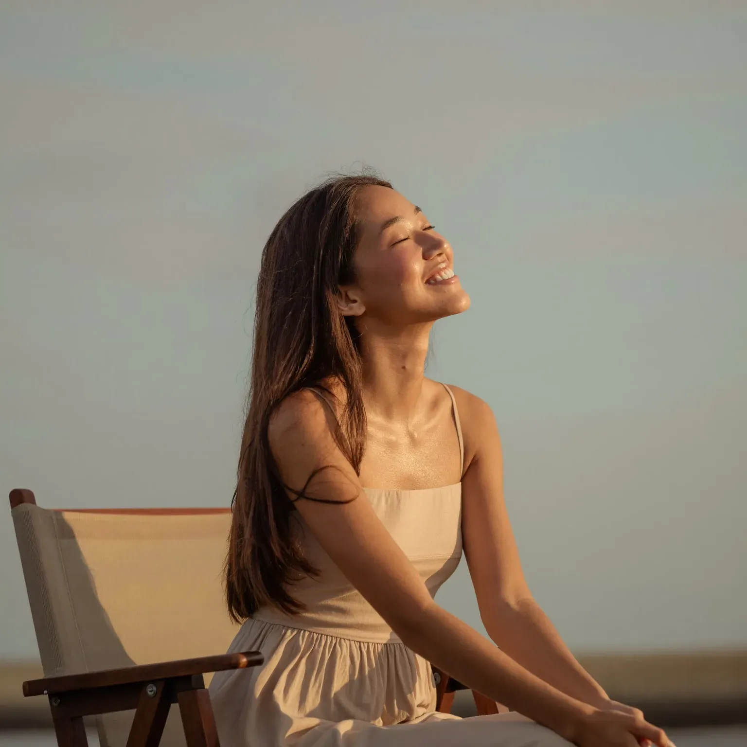 A woman sitting in the sun with her eyes closed