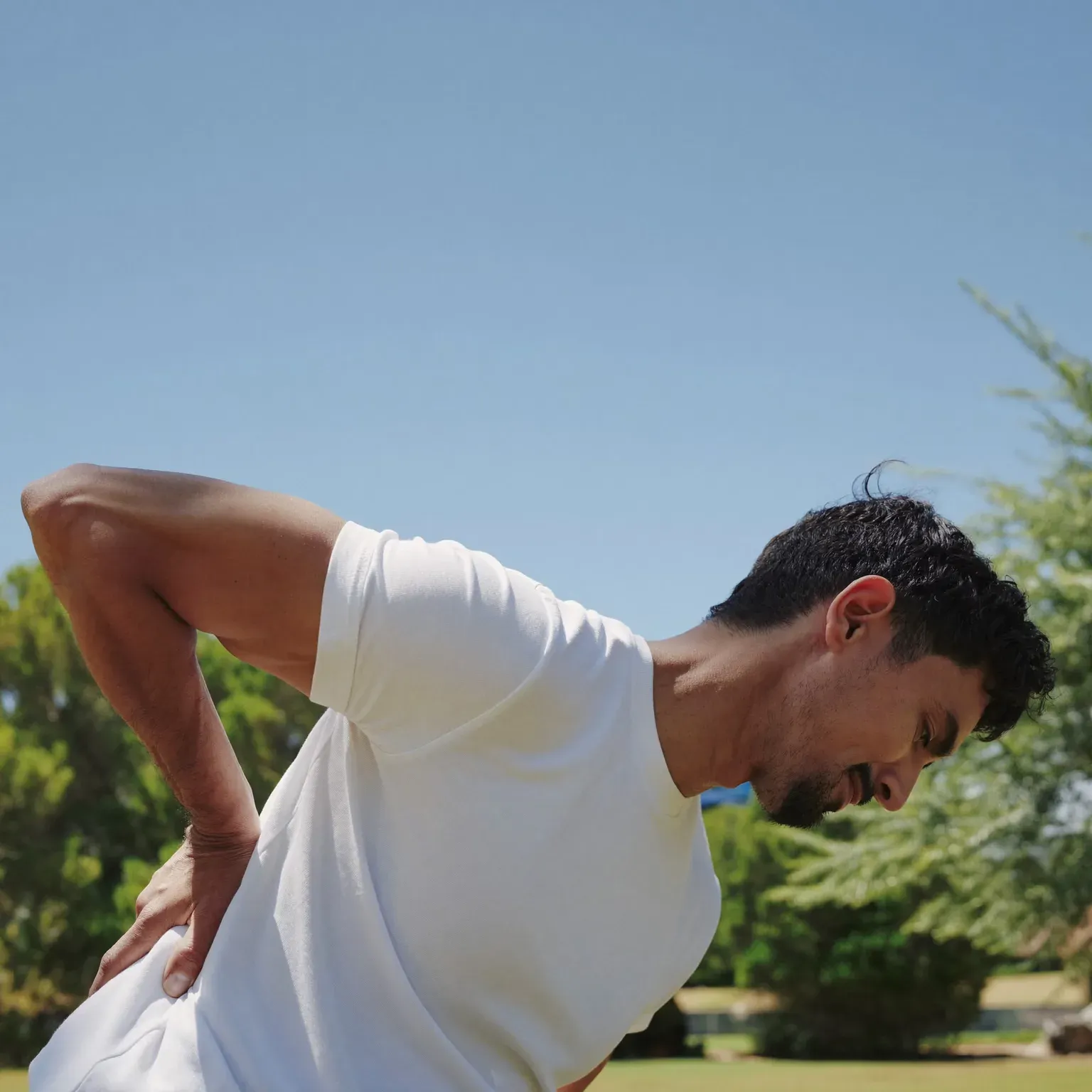 A man bending forward with a hand on his lower back