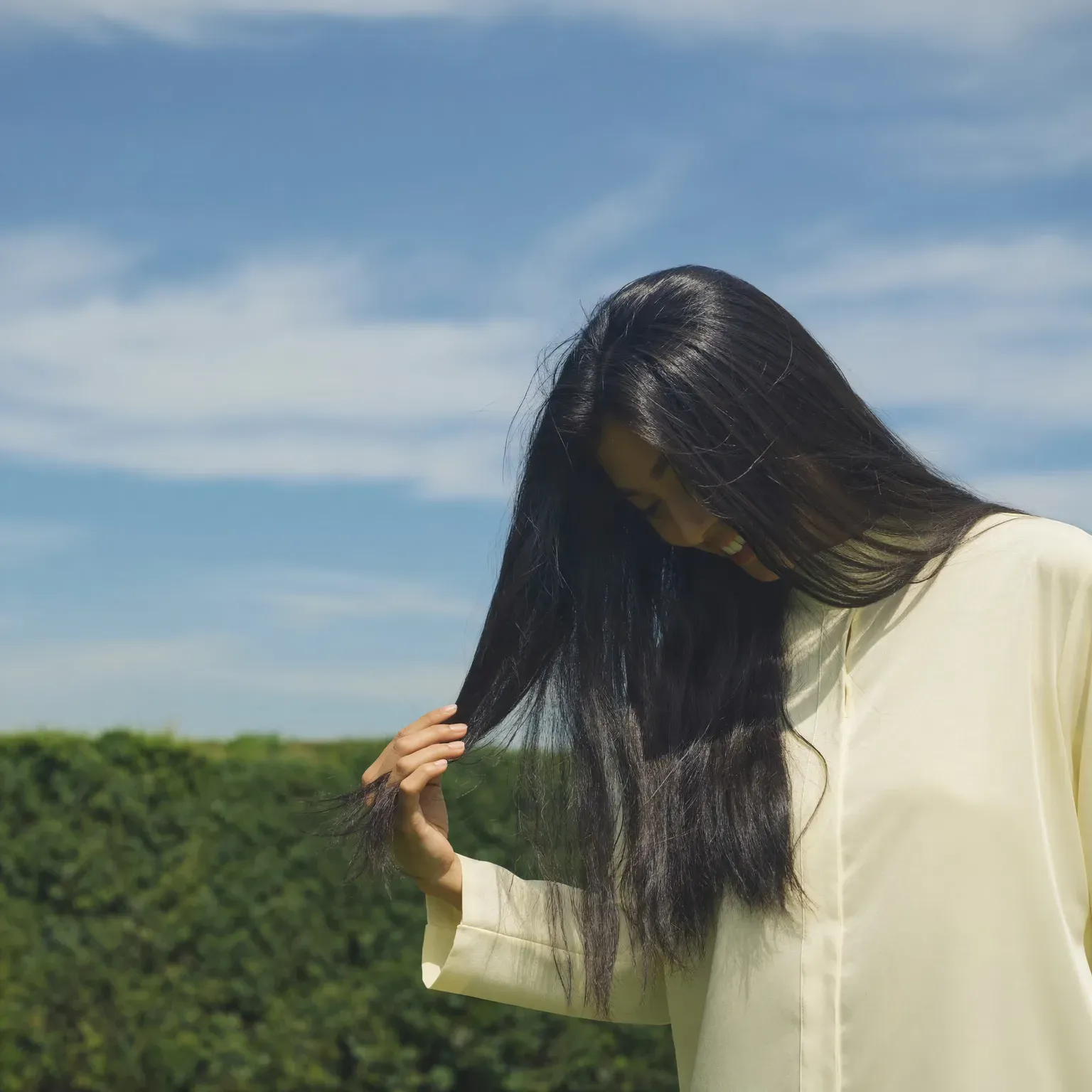 A woman running her fingers through the ends of her long hair