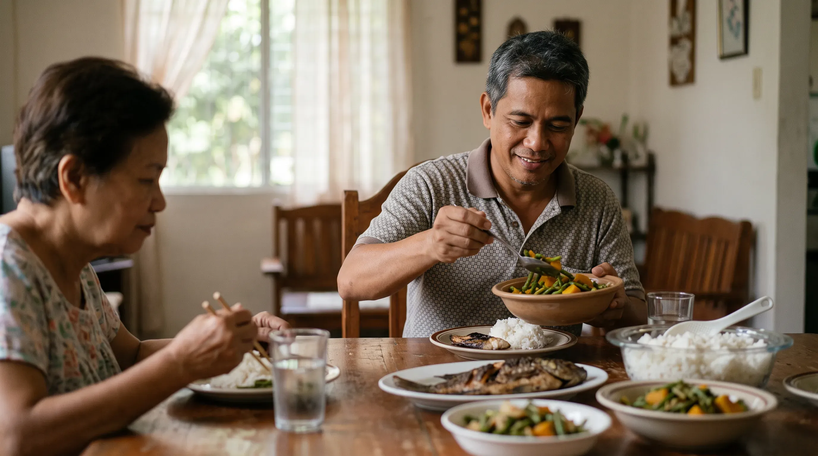 A man serving himself vegetables at a family table